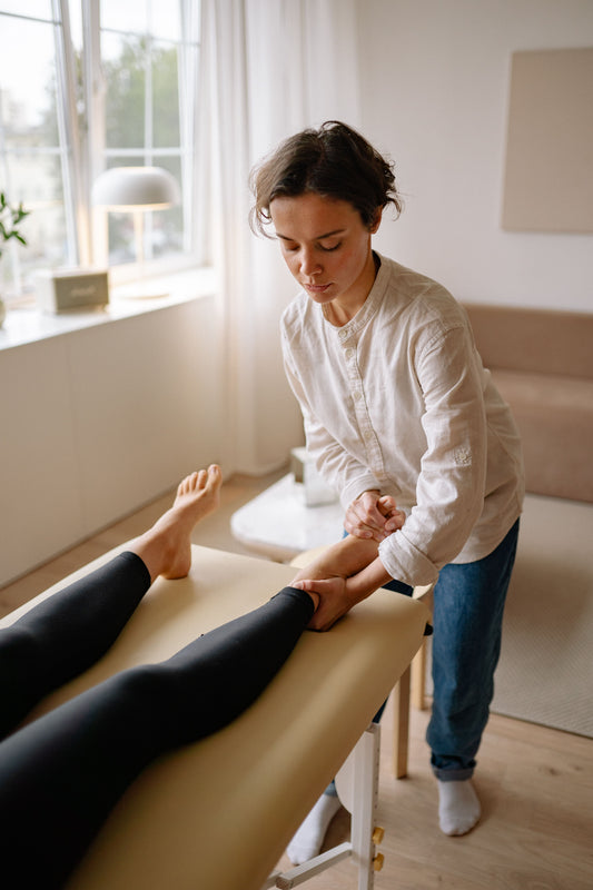 Therapist performing a professional leg massage on a patient in a wellness studio